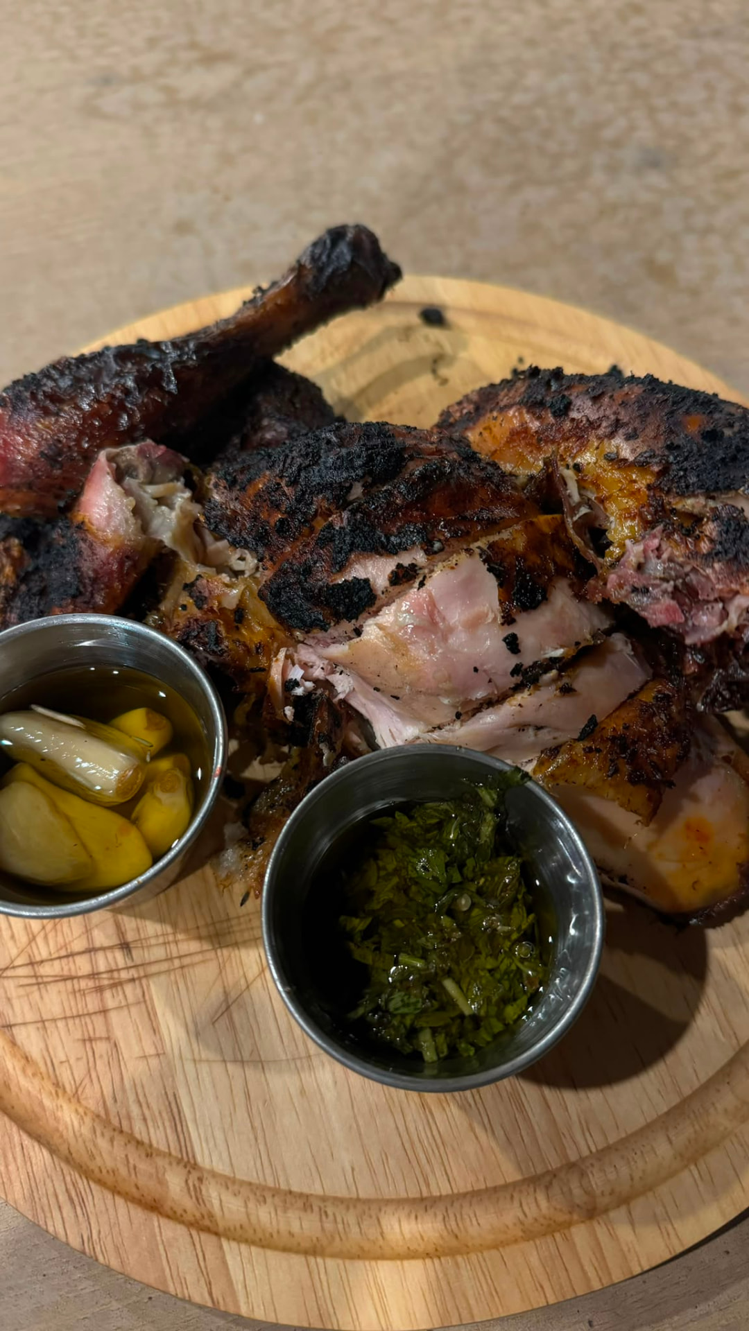 Fire-roasted chicken served with chimichurri and confit garlic