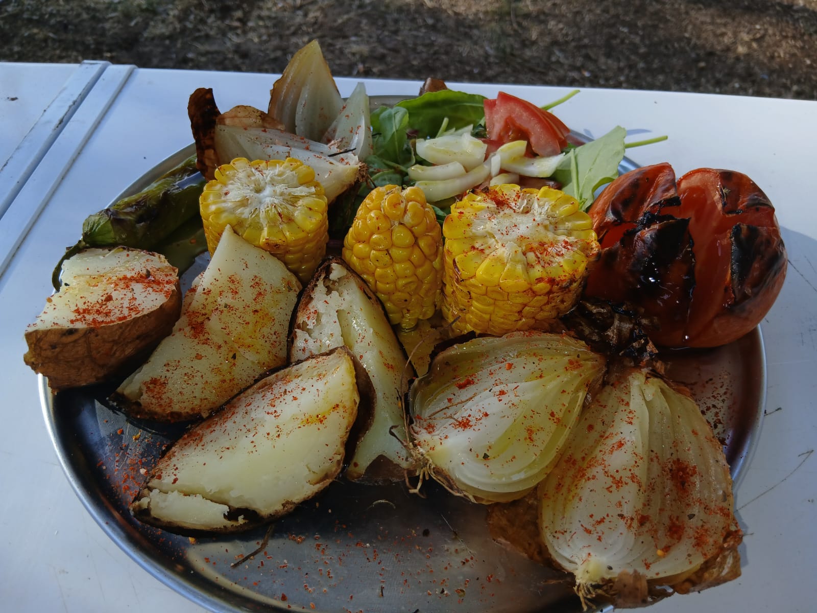 Platter of grilled potatoes, onions, corn and tomato