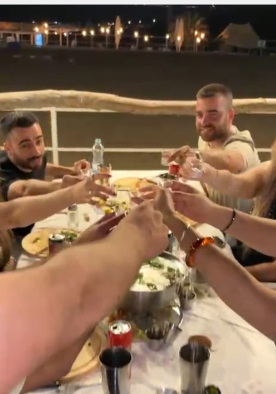 Guests raising a toast around the table on an asado night