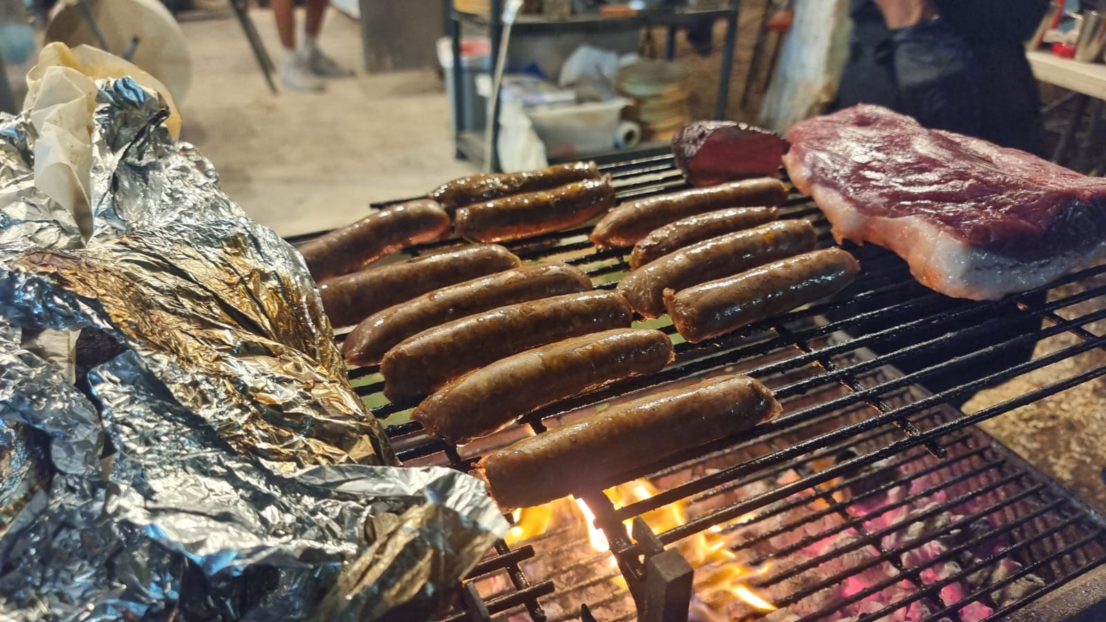 Chorizo sausages and a cut of beef on the parrilla