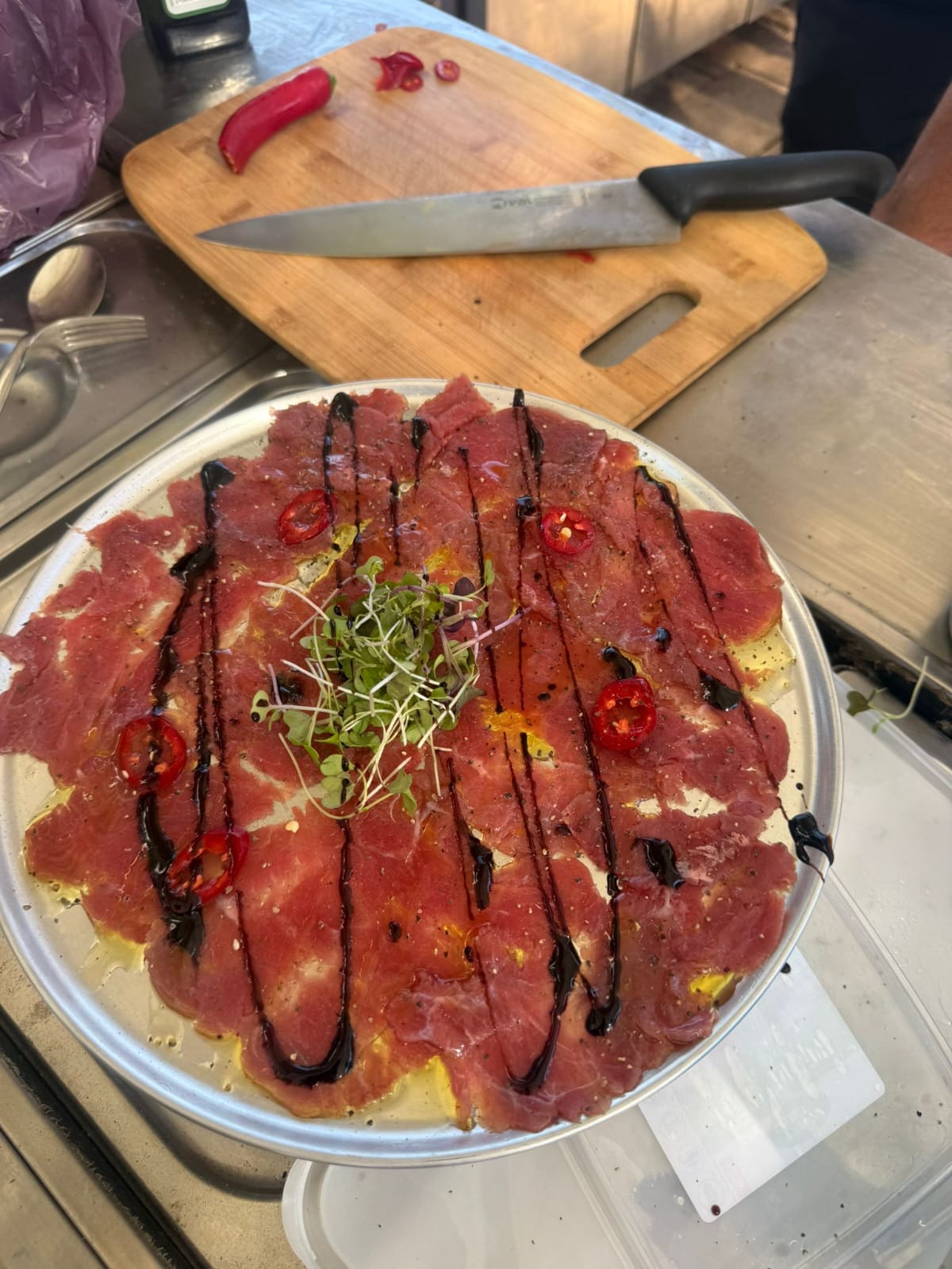 Beef carpaccio with balsamic dressing, greens and peppers