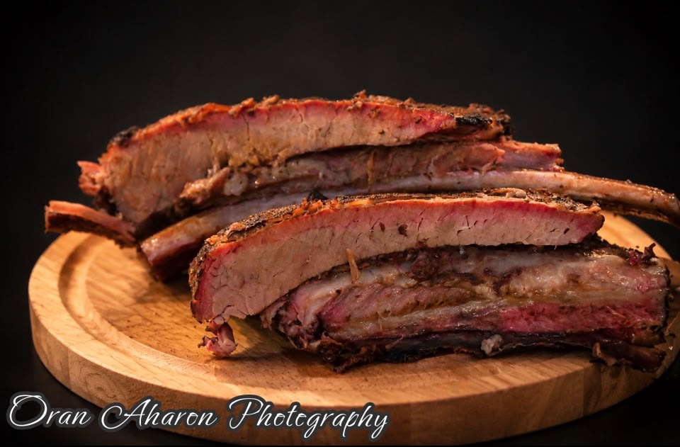 Smoked ribs stacked on a wooden board